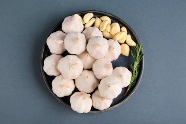 Taze sarımsaklı tabak ve gri arka planda biberiye.