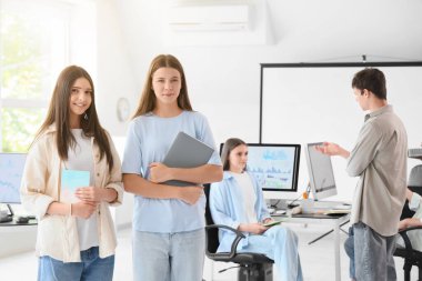 Okuldaki bilgisayar laboratuvarında not defterleri olan kız öğrenciler.