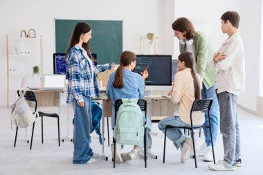 Okulun bilgisayar laboratuvarında okuyan bir grup genç öğrenci.