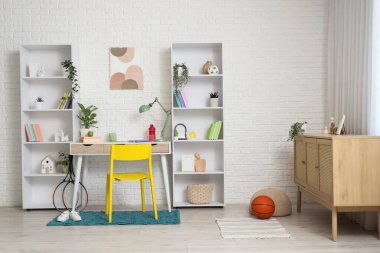 Çalışma yeri ve raf üniteleri olan çocuk odasının içi