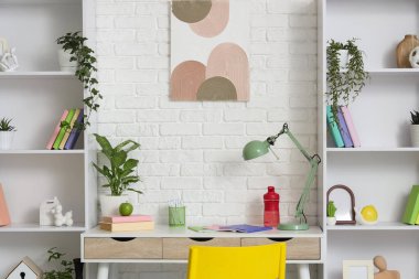 Çalışma yeri ve raf üniteleri olan çocuk odasının içi