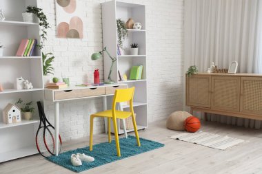 Çalışma yeri ve raf üniteleri olan çocuk odasının içi