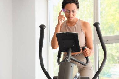 Spor salonunda gözlüklü Afro-Amerikalı bir kadın.