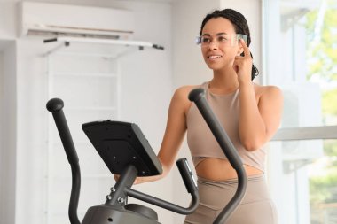 Spor salonunda gözlüklü Afro-Amerikalı bir kadın.