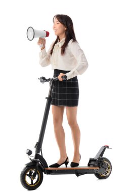 Elektrikli scooterlı genç Asyalı iş kadını beyaz arka planda megafona bağırıyor.