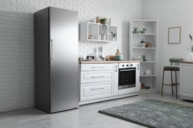 Modern buzdolabı, tezgah ve rafları olan mutfağın içi.