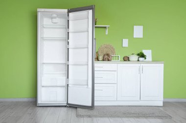 Boş buzdolabı ve tezgahları olan şık bir mutfak.