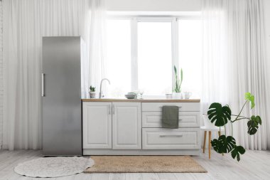 Modern buzdolabı, tezgah ve pencereli mutfağın içi.