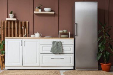 Modern buzdolabı, tezgah ve rafları olan şık bir mutfak.