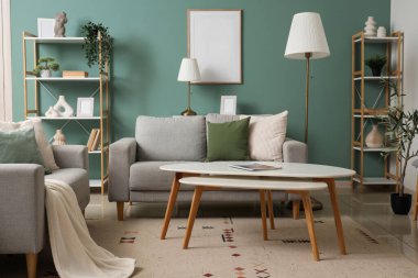 Lambaları, gri koltukları ve raf üniteleri olan şık bir oturma odası.