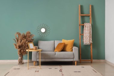 Gri kanepesi, masası ve merdiveni olan şık bir oturma odası.