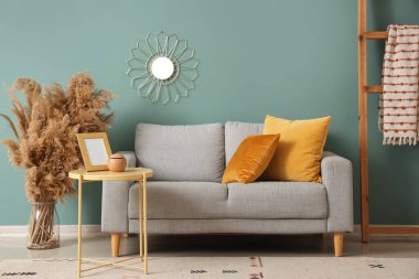 Gri kanepesi, masası ve merdiveni olan şık bir oturma odası.