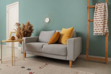 Gri kanepesi, masası ve merdiveni olan şık bir oturma odası.