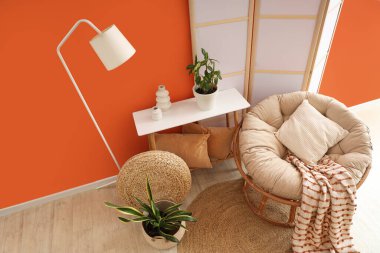 Beyaz lamba, koza sandalye ve katlanır ekranlı şık bir oturma odası.