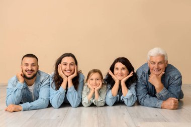 Bej duvarın yanında duran büyük bir ailenin portresi