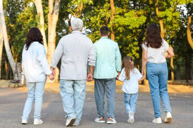 Büyük bir aile parkta yürüyor.