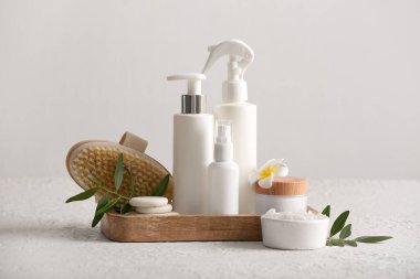 Masaj kabı vücut fırçası, kavanoz ve beyaz grunge arka plan kozmetik ürünleri şişeleri, yakın çekim