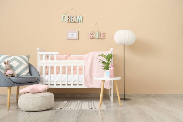 Interior of nursery with crib, armchair and lamp
