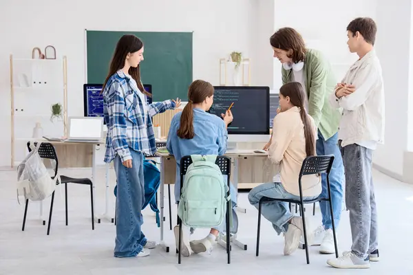 Okulun bilgisayar laboratuvarında okuyan bir grup genç öğrenci.