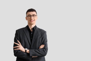 Beyaz arka planda siyah takım elbiseli yakışıklı bir iş adamı.