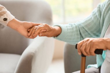 Sopası ve kızı olan son sınıf öğrencisi bir kadın evde el ele tutuşuyor, yakın plan.