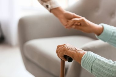 Sopası ve kızı olan son sınıf öğrencisi bir kadın evde el ele tutuşuyor, yakın plan.