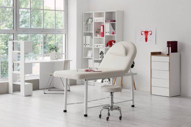 İş yeri, kanepe ve raf ünitesi olan jinekoloğun bürosu.