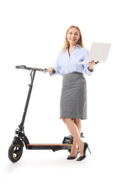 Beyaz arka planda dizüstü bilgisayarı ve elektrikli scooter 'ı olan olgun bir iş kadını.