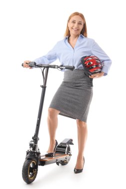 Beyaz arka planda kaskı ve elektrikli scooterı olan olgun bir iş kadını.