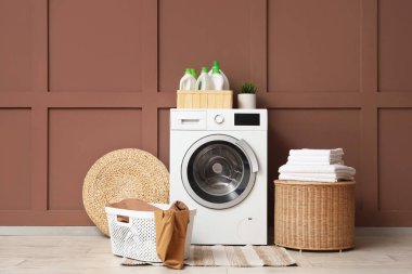 Çamaşır makinesi ve sepetli çamaşır odasının içi.