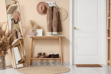 Koridorun içinde askı, ayna ve kapı var.