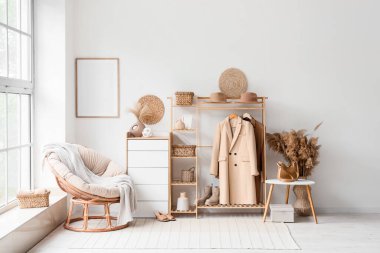 Palto askılı, koltuklu ve otlu ışık odasının içi.