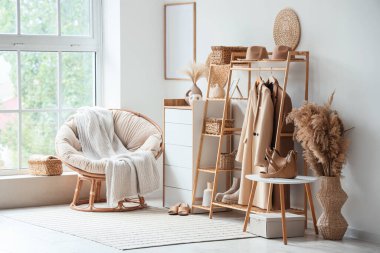 Palto askılı, koltuklu ve otlu ışık odasının içi.