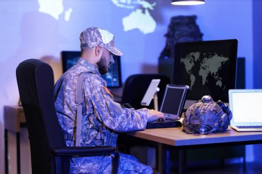 Askerler geceleri masada dizüstü bilgisayarla çalışıyorlar.