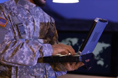 Askerler gece ofiste dizüstü bilgisayarla çalışıyor, yakın plan.