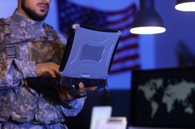 Askerler gece ofiste dizüstü bilgisayarla çalışıyor, yakın plan.