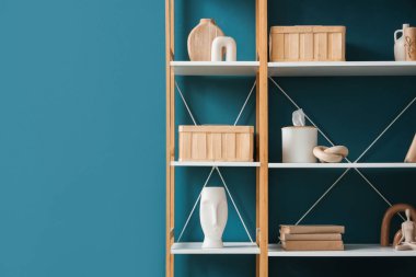 Mavi duvarın yanında şık dekorlu kitaplık