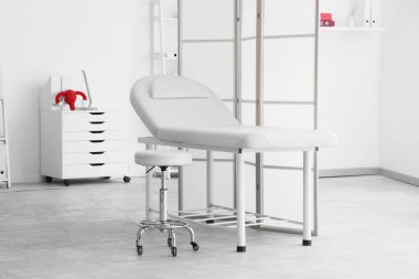 Kanepesi ve katlanır perdesi olan jinekoloğun ofisi.