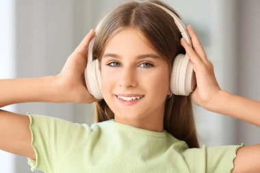 Kulaklıklı genç kız evde müzik dinliyor, yakın plan çekiyor.