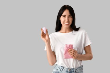 Aybaşı fincanı ve parlak arka planda çantası olan genç bir kadın.