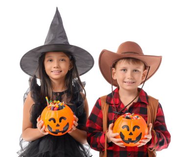 Cadılar Bayramı için giyinmiş küçük çocuklar ve beyaz arka planda şekerler.