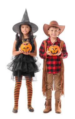 Cadılar Bayramı için giyinmiş küçük çocuklar ve beyaz arka planda şekerler.