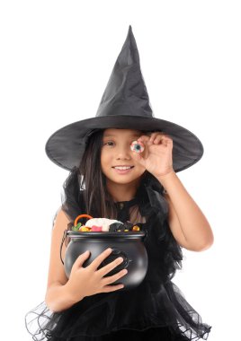 Cadılar Bayramı için cadı gibi giyinmiş tatlı Asyalı kız ve beyaz arka planda şekerler.