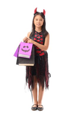 Cadılar Bayramı için giyinmiş şirin Asyalı kız. Beyaz arka planda hediye çantaları var.