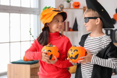 Cadılar Bayramı için giydirilmiş küçük çocuklar ve evde şekerler.