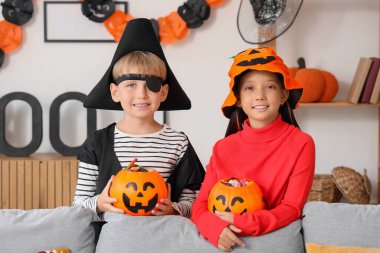 Cadılar Bayramı için giydirilmiş küçük çocuklar ve evde şekerler.