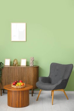 Oturma odasının içinde koltuk ve meyve sepeti var.