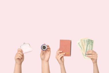 Cüzdanı, pusulası, pasaportu ve bej arka planda parası olan kadın elleri. Seyahat kavramı