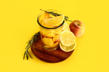 Taze şeftalili limonata ve biberiyeli ahşap tabak.