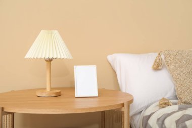 Boş çerçeve ve lambalı ahşap komodin, yakın plan.